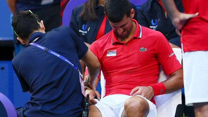 A trainer massages Novak Djokovic's right arm during a break in his match against Alex de Minaur. Photo / AP