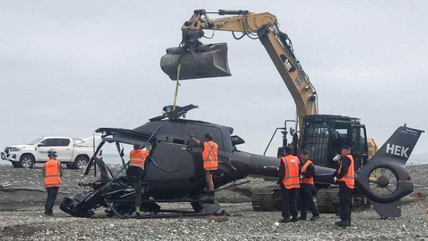 The wreckage of the helicopter is removed from Kēkerengū Beach. Photo / Anna Leask