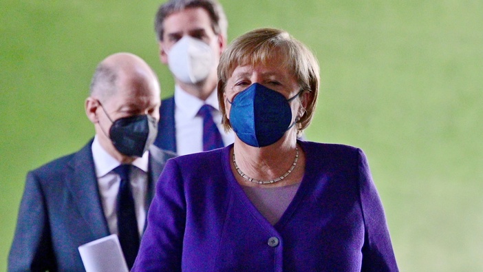 German Chancellor Angela Merkel, followed by Finance Minister Olaf Scholz, left, arrives for a press conference following a meeting with the heads of government of Germany's federal states at the Chancellery in Berlin, Thursday, Dec. 2, 2021. (Photo / AP)