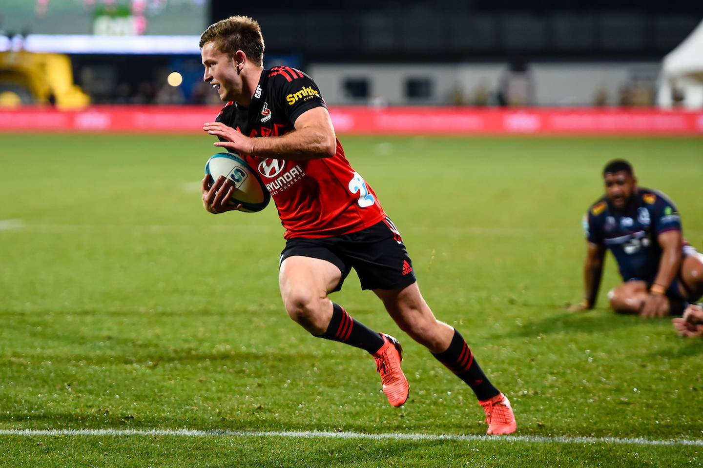Fergus Burke, of the Crusaders, scores a try against the Reds. Photo / Photosport