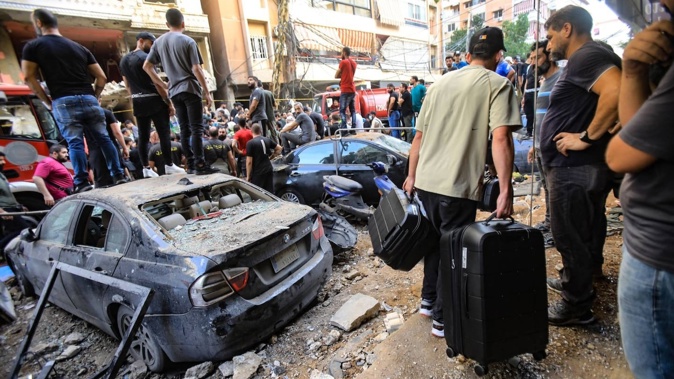 People gather in front of a building targeted by an Israeli strike in Beirut's southern suburbs in September. Photo / AFP