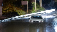 A man has climbed out of his car window after becoming trapped by floodwaters on Onehunga Harbour Rd, Onehunga, early this morning. Photo / Hayden Woodward