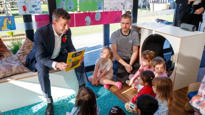 Associate Education Minister David Seymour reads to children during his visit to Co Kids in Wellington. Photo / Mark Mitchell