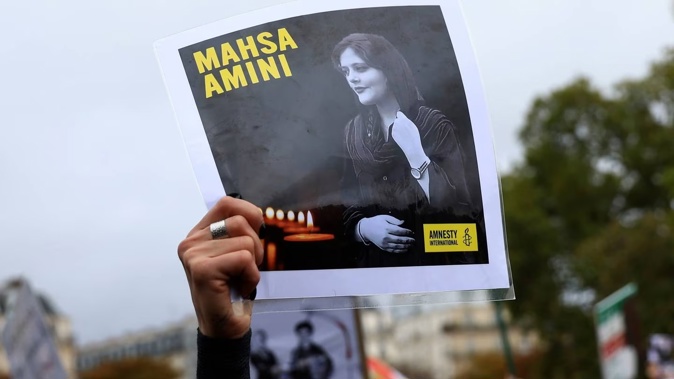 A protester shows a portrait of Mahsa Amini during a demonstration to support Iranian protesters standing up to their leadership over the death of a young woman in police custody. Photo / AP