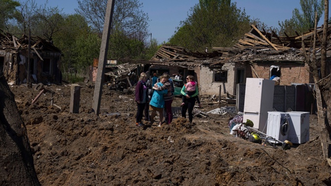 People react as they stand next to a crater in destroyed residential area after Russian airstrike in Bakhmut, Donetsk region, Ukraine, Saturday, May 7, 2022. (Photo / AP)