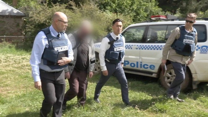 A man is led away by detectives. (Image / NSW Police)