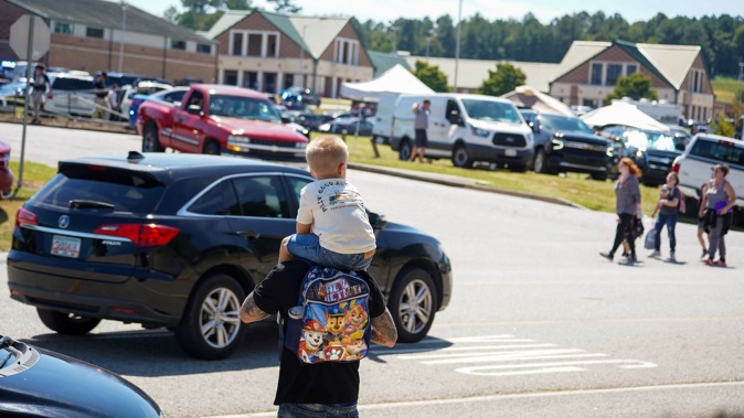 A father walks by Apalachee High School with his son on his shoulders after a school shooting in Winder, Georgia. Photo / Getty Images