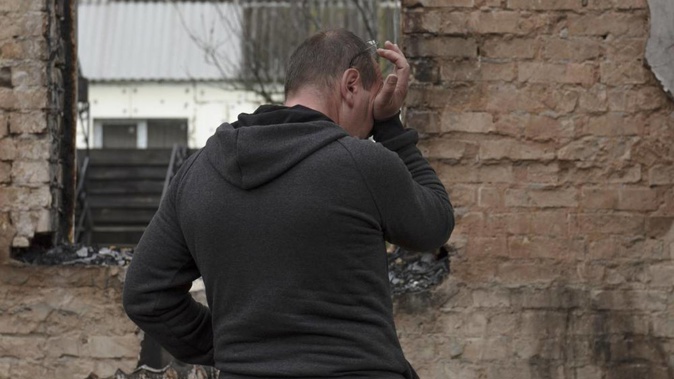 Vadym Zherdetsky reacts standing in the remains of his destroyed house, in the village of Moshun, outside Kyiv, Ukraine. Photo / AP