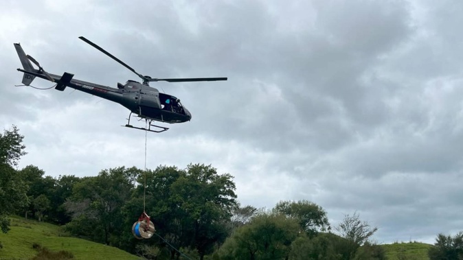 A helicopter lays fibre-optic cable inland from Gisborne after Cyclone Gabrielle. Photo / Chorus