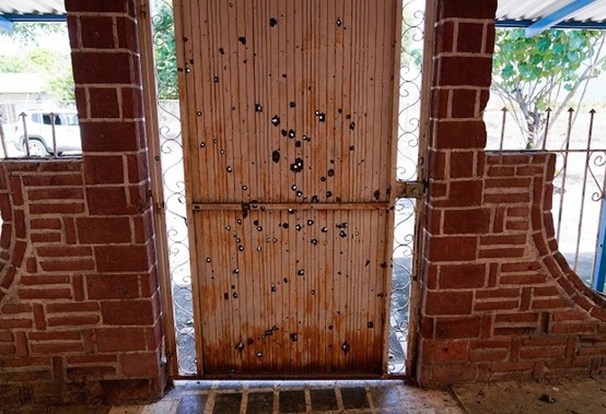 A door riddled with bullet holes in an abandoned home in El Limoncito in Michoacan state, Mexico. (Photo / AP)