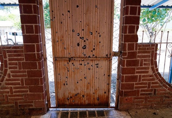 A door riddled with bullet holes in an abandoned home in El Limoncito in Michoacan state, Mexico. (Photo / AP)