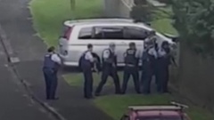 Police confront an armed man at the property, who was shot dead after opening fire at officers.