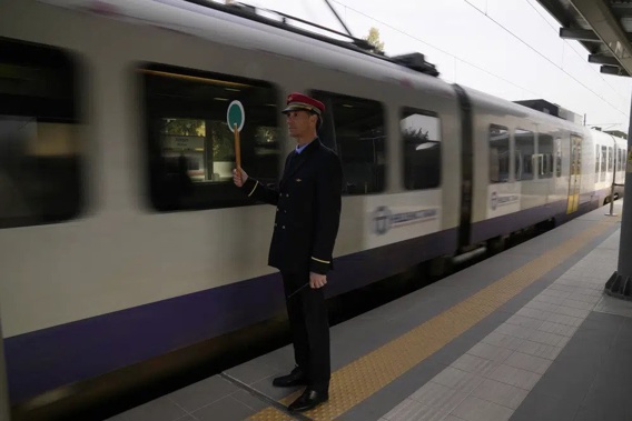 A station master uses a signalling disc for the departure of a train at the main station in Athens, Greece, Wednesday, March 22, 2023. Train services have partially resumed in Greece for the first time since a deadly rail disaster three weeks ago, as the country's center-right government struggles to regain its footing ahead of a general election. (AP Photo/Thanassis Stavrakis)
