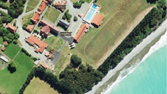An aerial image taken this year shows coastal erosion encroaching upon the grounds of Waitaki Boys’ High School. Photo / Google Maps