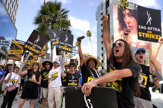 Sag-Aftra member John Schmitt, second from right, and others carry signs on the picket line outside Netflix in Los Angeles. Photo / AP