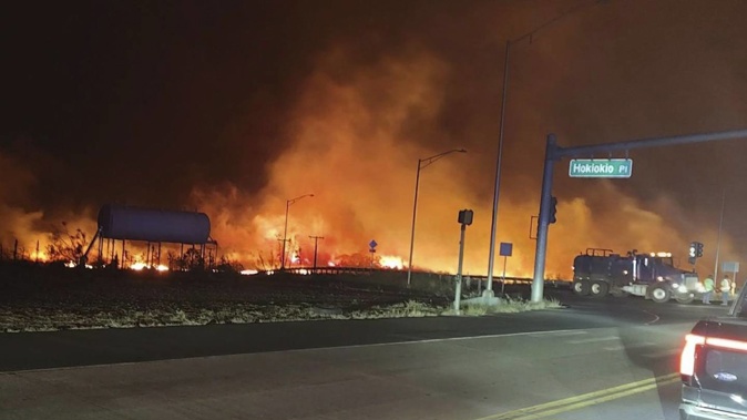 Wildfires in Hawaii fanned by strong winds burned multiple structures in areas including the historic town of Lahaina, forcing evacuations and closing schools in several communities on Wednesday, and rescuers pulled a dozen people escaping smoke and flames from the ocean. Photo / AP
