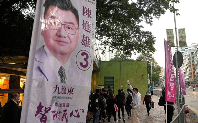 Jeffery Chan, a so-called "non-establishment" candidate and a member of local think tank Path of Democracy, delivers the promotional leaflets to residents during his legislative election campaign in Hong Kong on Dec. 8, 2021. (Photo / AP)