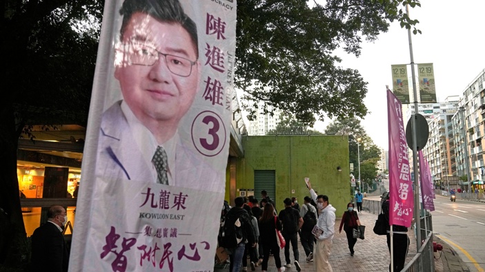 Jeffery Chan, a so-called "non-establishment" candidate and a member of local think tank Path of Democracy, delivers the promotional leaflets to residents during his legislative election campaign in Hong Kong on Dec. 8, 2021. (Photo / AP)