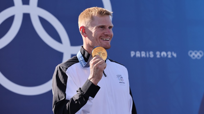 Gold medalist Finn Butcher of Team New Zealand stands on the podium during the Canoe Slalom Men's Kayak Cross medal ceremony. (Photo by Tnani Badreddine/DeFodi Images via Getty Images)