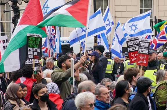 People take part in a pro-Palestine march as they walk past a counter-protest with Israeli flags, at Waterloo Place in central London. Photo / AP