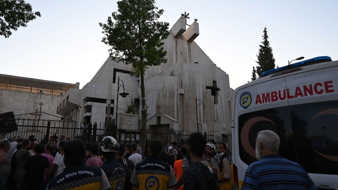 People and rescuers gather at the site of a reported suicide attack at St Elias church in Damascus' Dwelaa area on June 22, 2025. Photo / Louai Beshara, AFP