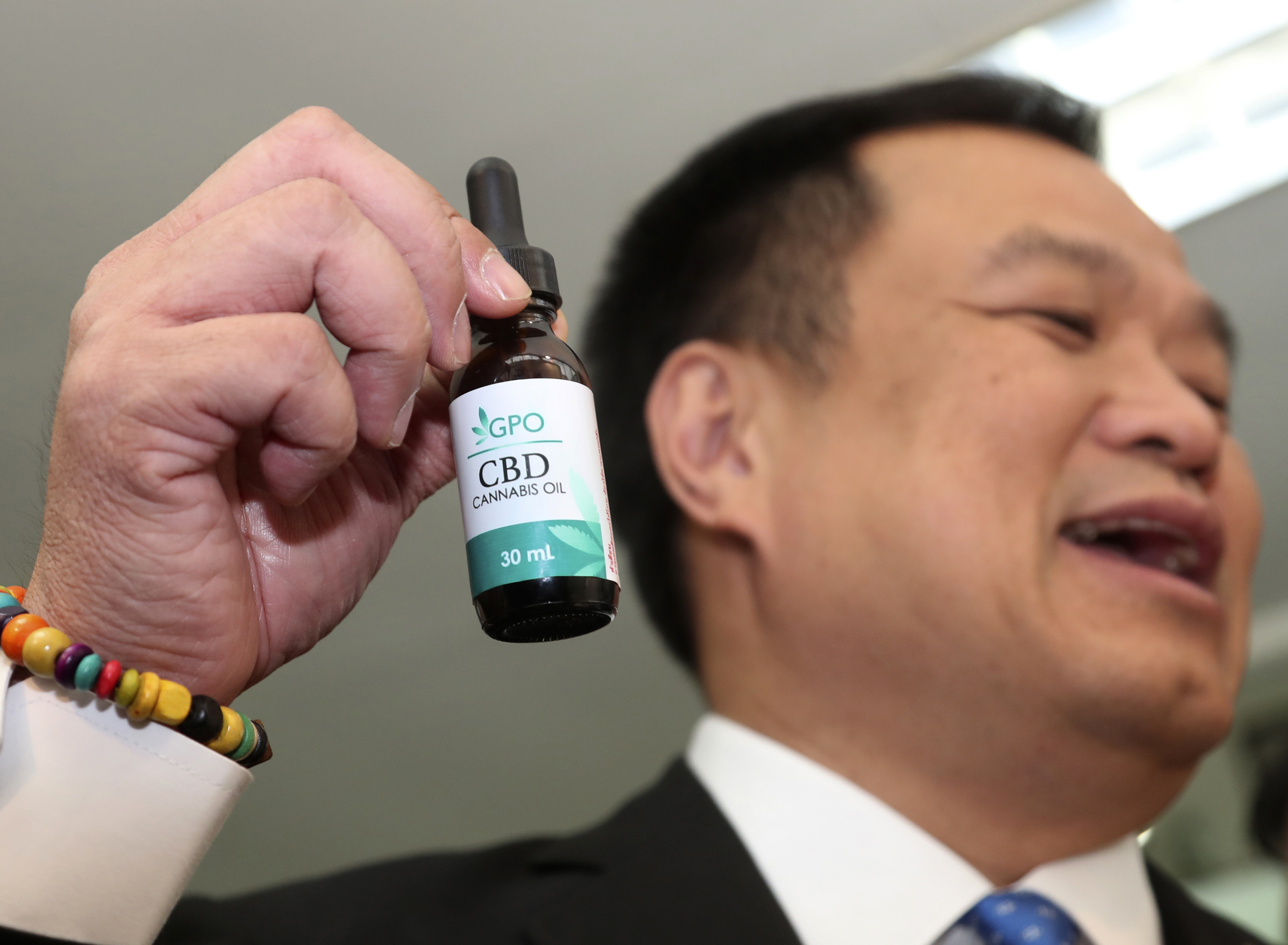 Thailand's Public Health Minister Anutin Chanvirakul shows off a bottle of extracted cannabis oil. (Photo / AP)