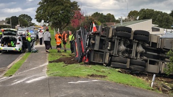 Truck overturns, crashes into property on Hobsonville Rd