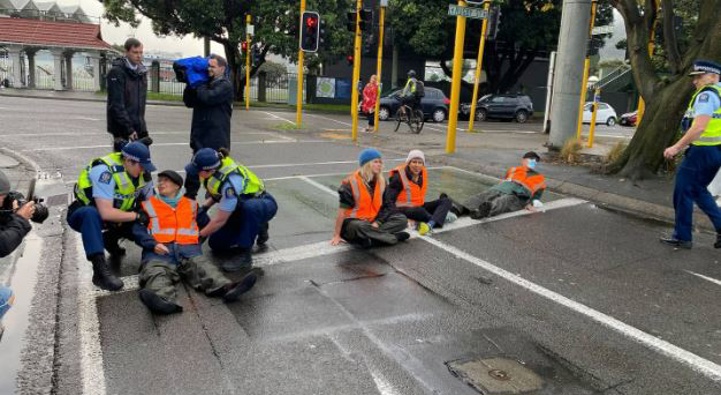 Passenger rail protesters glued themselves to the road at the Basin Reserve. Photo / Vita Molyneux