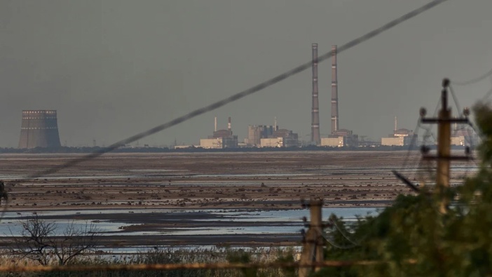 A 2023 file photo of Zaporizhzhia nuclear power plant, Europe's largest, is seen in the background of the shallow Kakhovka Reservoir. Libkos/AP/File