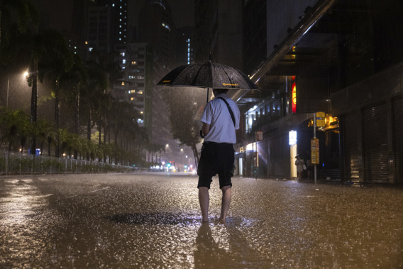 A pedestrian waits for a bus on a flooded street following heavy rainstorms in Hong Kong, Friday, Sept. 8, 2023. Photo / AP