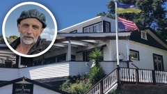 Mario Schmidt (inset) and the Ukrainian flag above an upside-down US flag outside of his B&B on Bluff Hill, Napier.