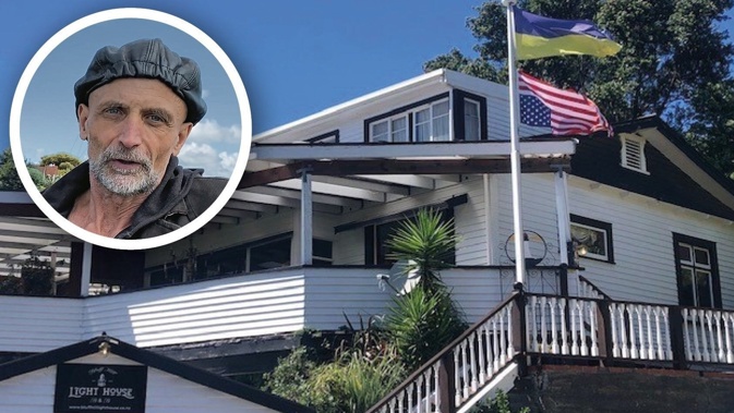 Mario Schmidt (inset) and the Ukrainian flag above an upside-down US flag outside of his B&B on Bluff Hill, Napier.