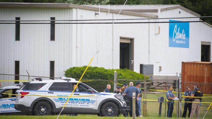 Law enforcement officials stand near the scene of a shooting at Columbia Machine Inc. Photo / AP