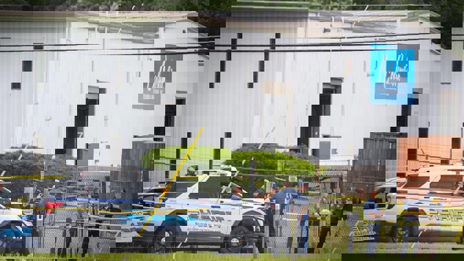 Law enforcement officials stand near the scene of a shooting at Columbia Machine Inc. Photo / AP