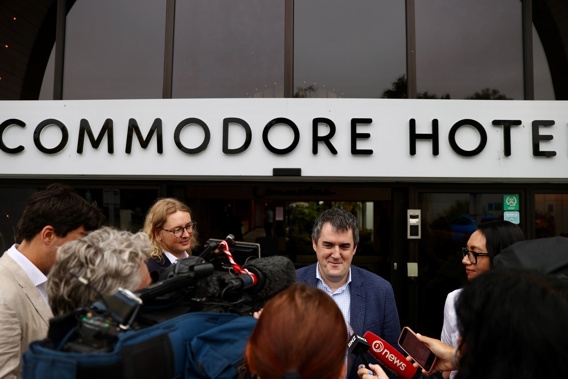 Housing Minister, Chris Bishop addresses the press outside the Commodore Hotel, ahead of his party's annual retreat. Photo / George Heard