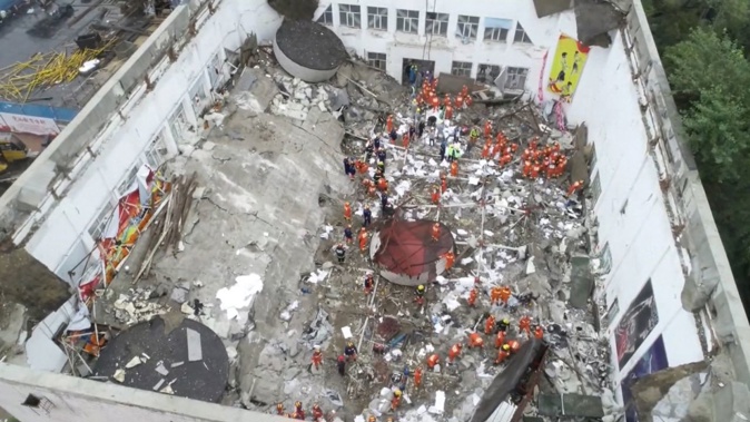 Rescue workers respond after the collapse of a roof on a middle school gymnasium in China's northeastern city of Qiqihar. CCTV