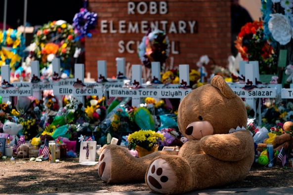 A teddy bear sits in front of crosses with the names of the 21 victims killed at Robb Elementary School. (Photo / AP)