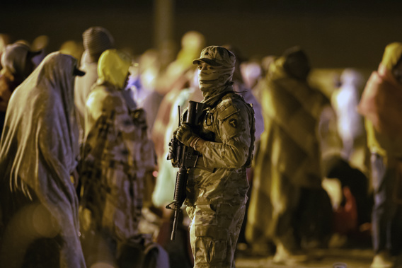 A Texas National Guard soldier provides security around migrants gathered around a gate in the border fence in El Paso, Texas, in the early hours of Thursday, May 11, 2023. Photo / AP