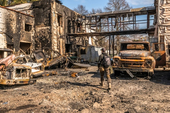 Ukrainian soldiers and foreign fighters walk through burnt vehicles and buildings during a clearing-out operation of remaining Russian forces in Irpin, Ukraine. (Photo / AP)