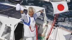 Kenichi Horie waves from his yacht Suntory Mermaid III after his trans-Pacific voyage. Photo / AP