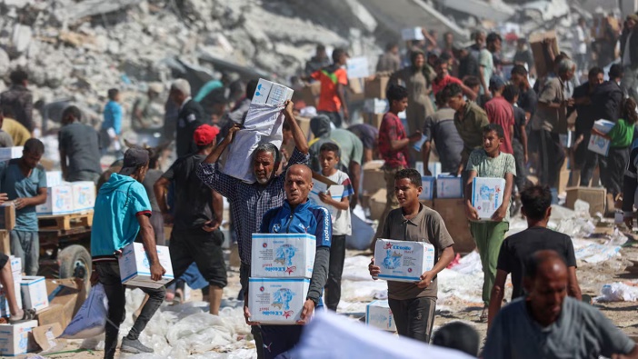 Palestinians receive food parcels after aid trucks entered from the Karem Abu Salem crossing, in Khan Yunis in the southern Gaza Strip. Photo / Omar Al-Qatta, AFP