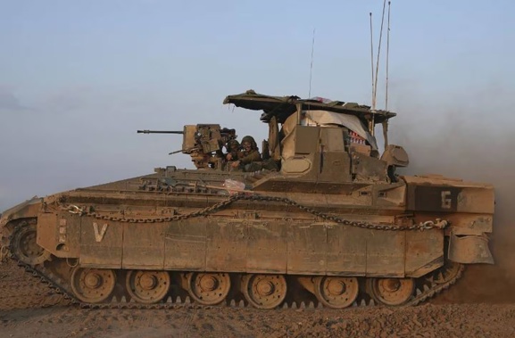 An Israeli soldier smiles from the turret of his armored vehicle in southern Israel near the Gaza border. Photo / AP