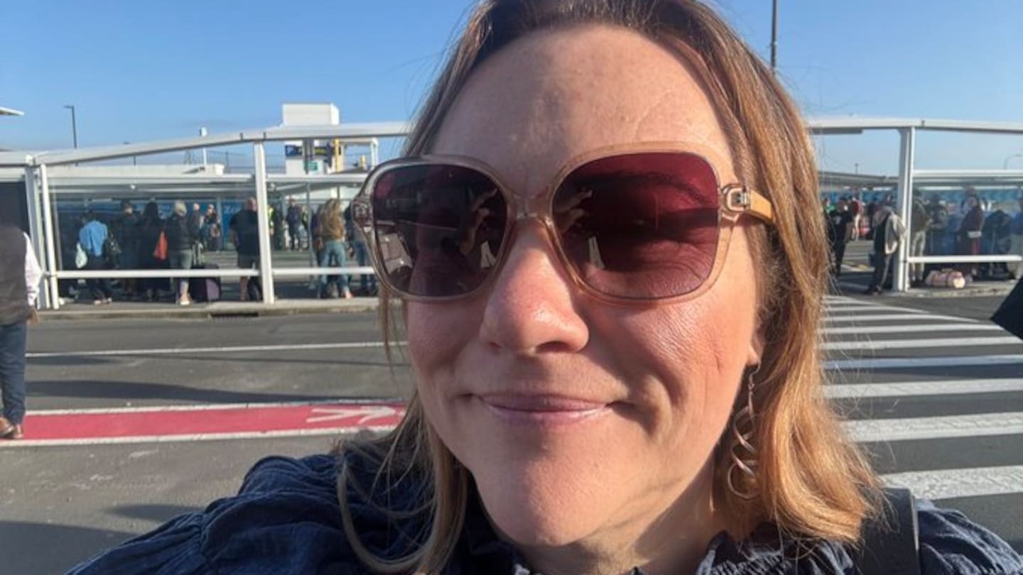 Nelson MP Rachel Boyack pictured waiting outside after Auckland Airport's domestic terminal was evacuated this morning. Photo / X