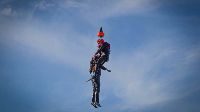 A young woman is winched from the sea by helicopter off the Marine Parade coast. Photo Warren Buckland