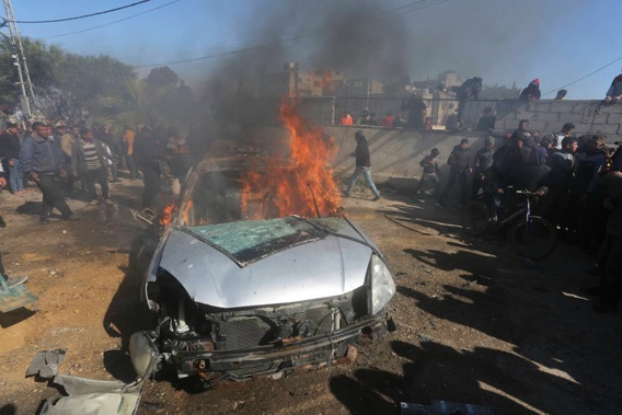Palestinians watch a car burn after it was hit by an Israeli strike in Rafah, Gaza Strip. Photo / AP