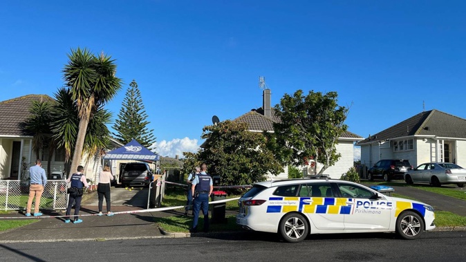 Police yesterday examining the Glen Innes driveway where the violent shooting took place. (Photo / Miriam Burrell)