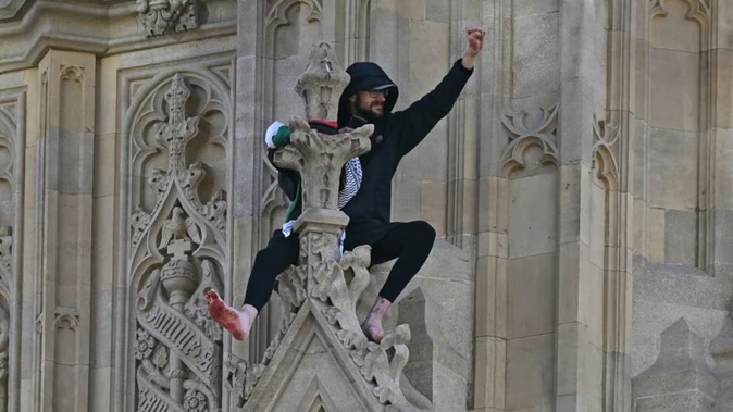 A protester climbed London’s Big Ben clock tower. Photo / AFP