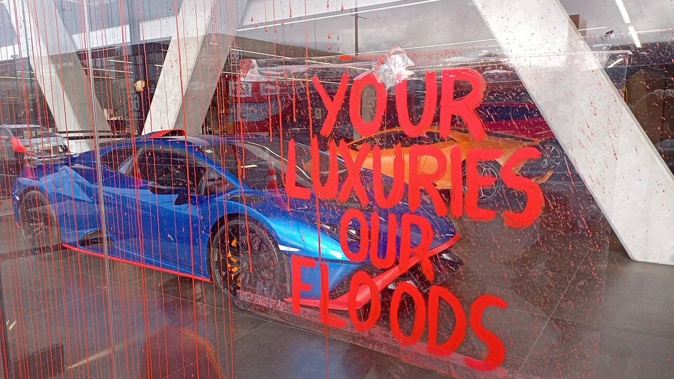 A Restore Passenger Rail protester has vandalised Auckland car yards this morning in a protest against inequality and climate change. Photo / Supplied.