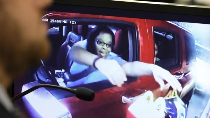 Philana Holmes reaching for two Happy Meals in the drive-thru at McDonald's is shown on a courtroom monitor. Photo / AP