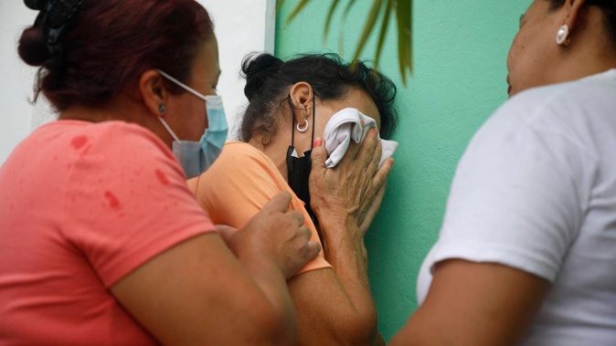Relatives of inmates wait in distress outside the entrance to the women's prison after a riot left at least 46 inmates dead, most of them burned to death. Photo / AP